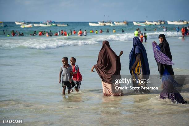 Women and children play in the shore at Lido beach on November 11, 2022 in Mogadishu, Somalia. With an estimated 7.8 million people affected famine...