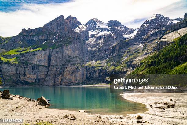 scenic view of lake and mountains against sky,oeschinen lake,kandersteg,switzerland - lac-oeschinensee photos et images de collection
