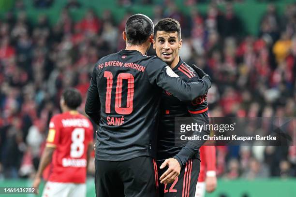 Leroy Sane of Bayern Munich celebrates with Joao Cancelo of Bayern Munich after scoring the team's third goal during the DFB Cup round of 16 match...