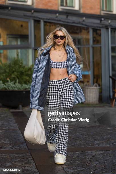 Teresa Jg wears cropped pepita top, pants, down feather jacket, white bag, moon bootsoutside Lovechild 1979 during the Copenhagen Fashion Week...