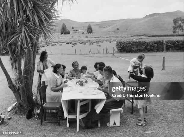 Sam Green, a sheep farmer in Tikitere near Rotorua on the North Island of New Zealand, at lunch with his wife and family, December 1953. Mrs Green is...