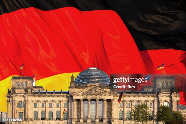 deutscher bundestag - reichstag building with german flags (german parliament building) - berlin, germany - german flag wallpaper stock-fotos und bilder