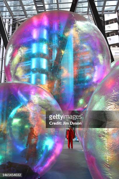 Members of the public interact with the iridescent orbs of 'Evanescent', an art installation by Sydney-based design studio Atelier Sisu, at The...