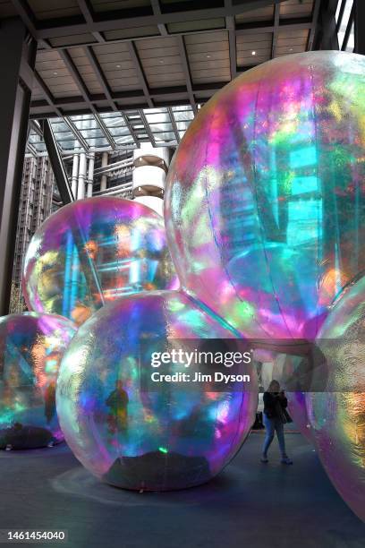 Members of the public interact with the iridescent orbs of 'Evanescent', an art installation by Sydney-based design studio Atelier Sisu, at The...