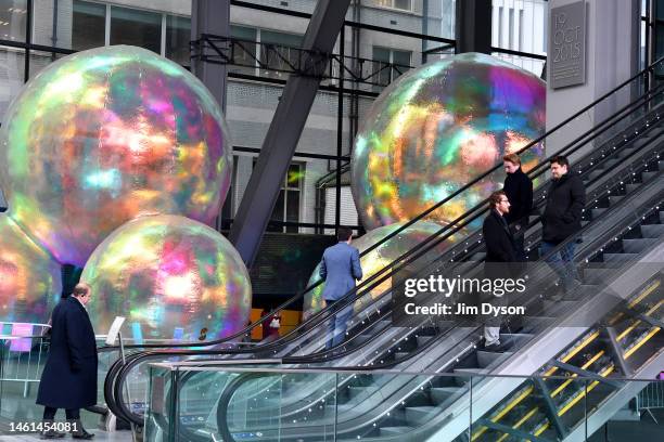 Members of the public interact with the iridescent orbs of 'Evanescent', an art installation by Sydney-based design studio Atelier Sisu, at The...