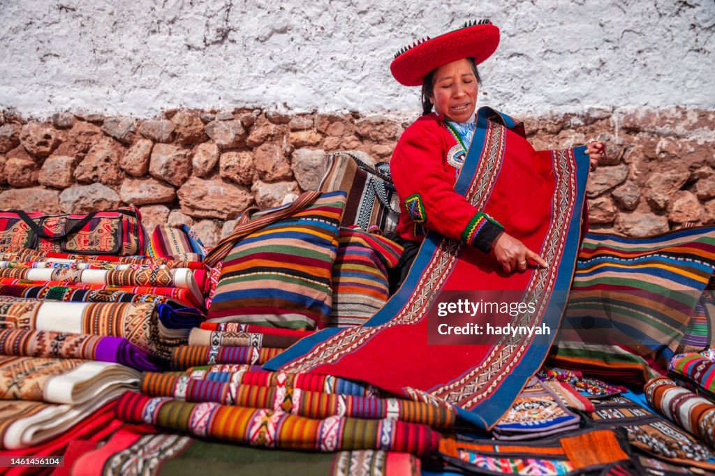 Peruvian woman selling souvenirs at Inca ruins, Sacred Valley, Peru
