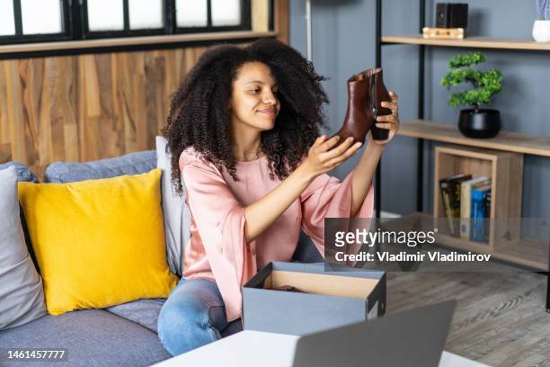 happy woman inspecting her new boots - parcel laptop stock pictures, royalty-free photos & images