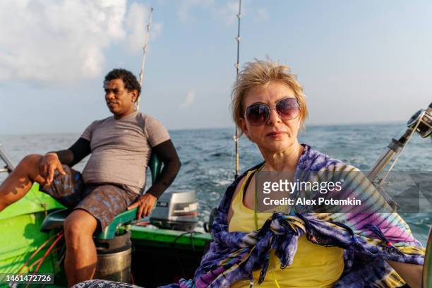 una guida e una turista, una donna europea, aspettano un boccone sulla pesca sportiva in acque profonde. - "alex potemkin" or "krakozawr" foto e immagini stock