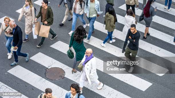 large group of people walking across crosswalk in city top view - pedestrian safety stock pictures, royalty-free photos & images