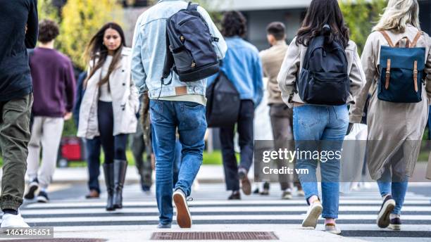 crowd of people walking across zebra in city - pedestrian safety stock pictures, royalty-free photos & images