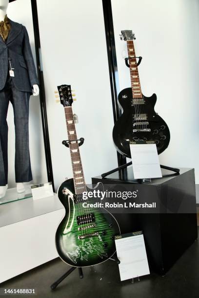 Slash" and "Sting" signed black Gibson Les Paul electric guitars are seen at Musicares Charity Relief Auction Press Preview at Julien's Auctions on...
