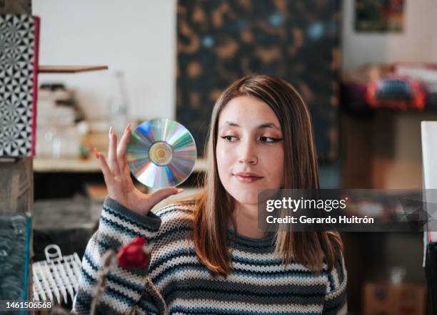 retrato de una mujer joven en una librería posando en un estilo vintage - compact disc fotografías e imágenes de stock