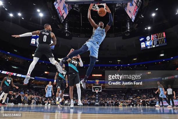 Jaren Jackson Jr. #13 of the Memphis Grizzlies dunks during the first half against Damian Lillard of the Portland Trail Blazers at FedExForum on...
