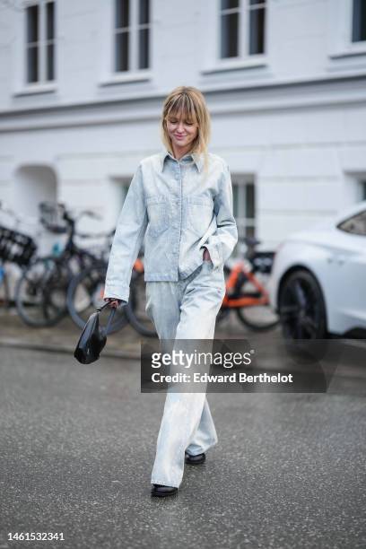 Jeanette Madsen wears a blue faded denim shirt, matching blue denim faded large pants, black shiny leather shoes , outside A. Roege Hove, during the...