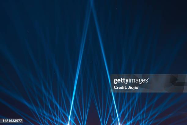 blue spotlights shining into sky - 射燈 個照片及圖片檔