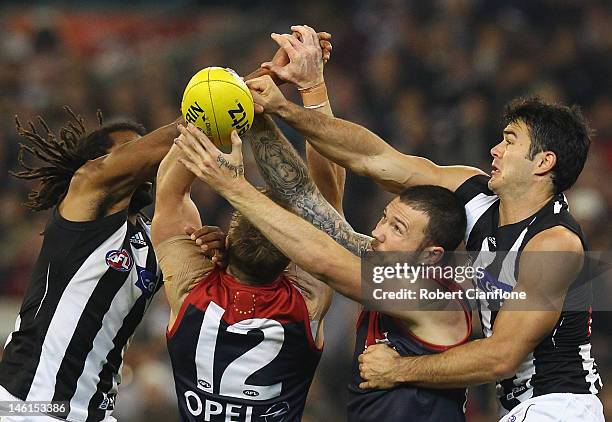 Mitch Clark of the Demons holds onto the ball as Chris Tarrant of the Magpies looks to spoil during the round 11 AFL match between the Melbourne...