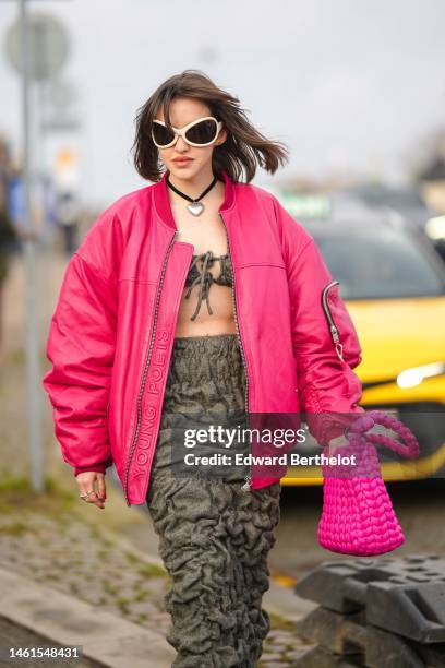 Guest wears white butterfly sunglasses, a black with silver heart pendant necklace, a brown shoulder-off / cropped top, a brown embossed pattern long...