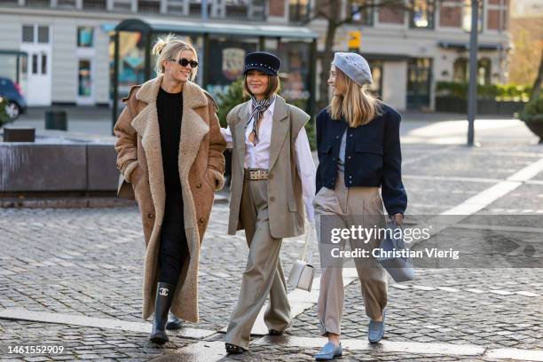 Gine Margrethe wears baker hat, brown vest, white button shirt, striped scarf, belted pants outside Lovechild 1979 during the Copenhagen Fashion Week...