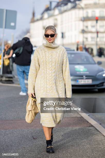 Hollie Mercedes Peters wears oversized turtleneck knit worn as a dress skirt, Bottega Veneta bag in beige, black shoes, socks outside OpéraSport...