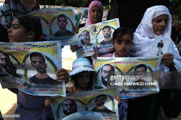 Palestinians hold posters of jailed Palestinian football player Mahmud Sarsak and prisoner Akram Rikhawi during a rally in solidarity with two...