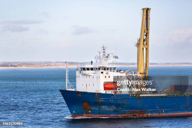 large cargo ship with crane in coastal waters - ship's bridge foto e immagini stock