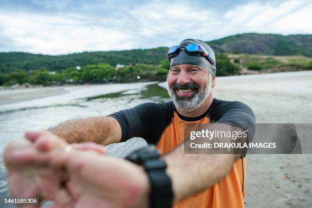 middle aged athlete preparing for swimming - bademütze stock-fotos und bilder
