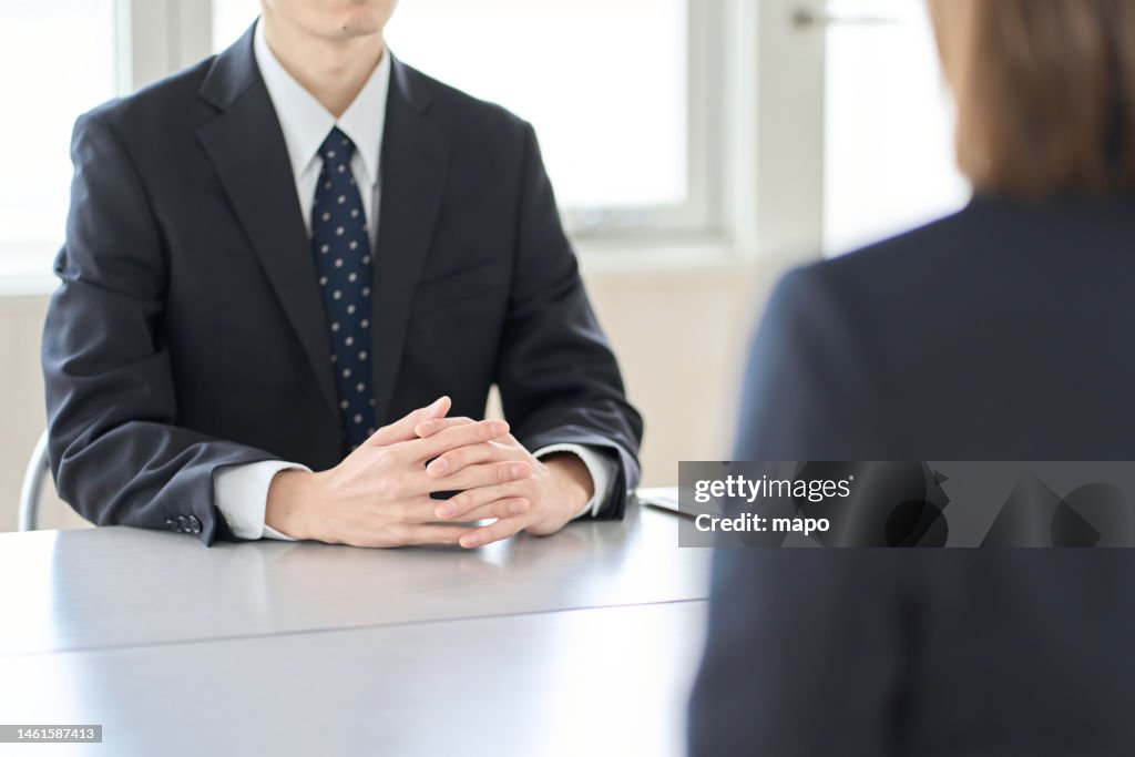 A man in a managerial position interviewing an employee