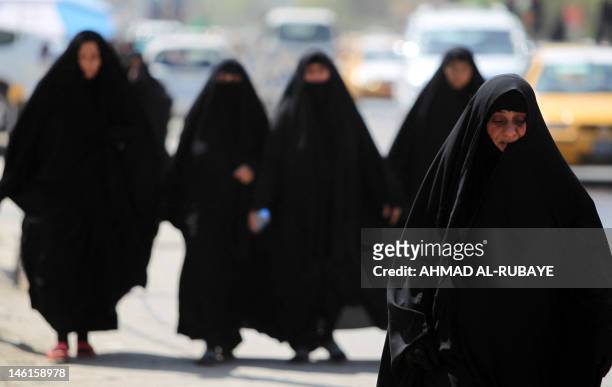Shiite Muslim women walk to the Kadhimiyah area of north Baghdad, to mark the anniversary of the death of Imam Musa Kadhim on June 11, 2012. Four...
