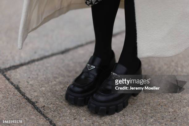 Sonia Lyson seen wearing Prada shiny black leather loafer, NA-KD beige long wool coat, Wolford black transparent socks on January 31, 2023 in Berlin,...