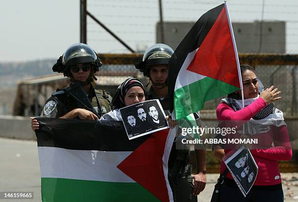 Israeli police keep guard as female Palestinian protestors fly their national flag and hold pictures of jailed Palestinian football player Mahmud...