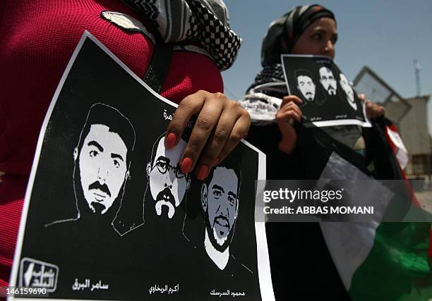 Female Palestinian protestors hold pictures of jailed Palestinian football player Mahmud Sarsak and prisoners Akram Rikhawi and Samir al-Baraka...