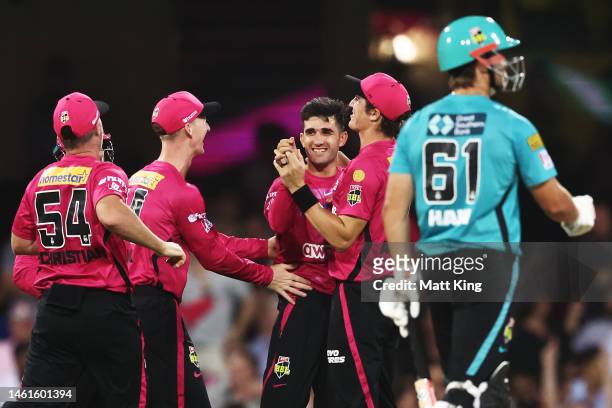 Izharulhuq Naveed of the Sixers celebrates with team mates after taking the wicket of Sam Hain of the Heat during the Men's Big Bash League match...