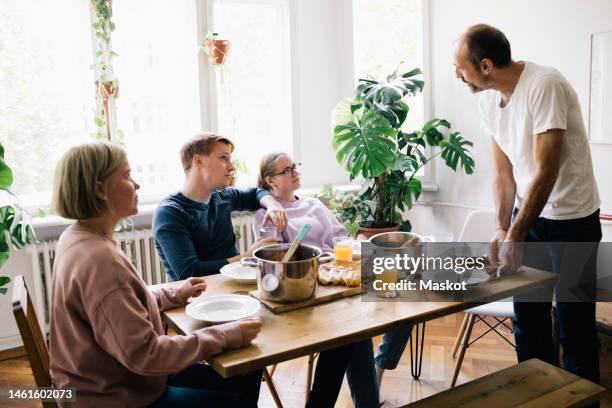 family talking with dad standing near table at home - boomerang generation stock pictures, royalty-free photos & images
