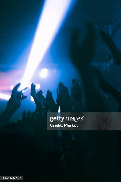 silhouette raised hands of women and men dancing at nightclub - concert for liberty stock-fotos und bilder