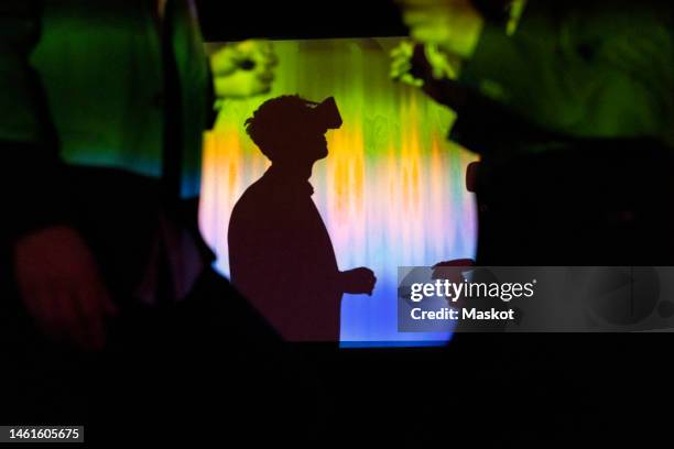 side view of businessman watching through virtual reality glasses in exhibition center - virtual fotografías e imágenes de stock