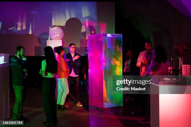 multiracial female and male entrepreneurs discussing strategy in conference event at exhibition center - entertainment evenement stockfoto's en -beelden