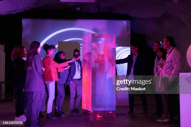 multiracial business colleagues discussing over glass display during seminar in conference event - virtual exhibition stock pictures, royalty-free photos & images