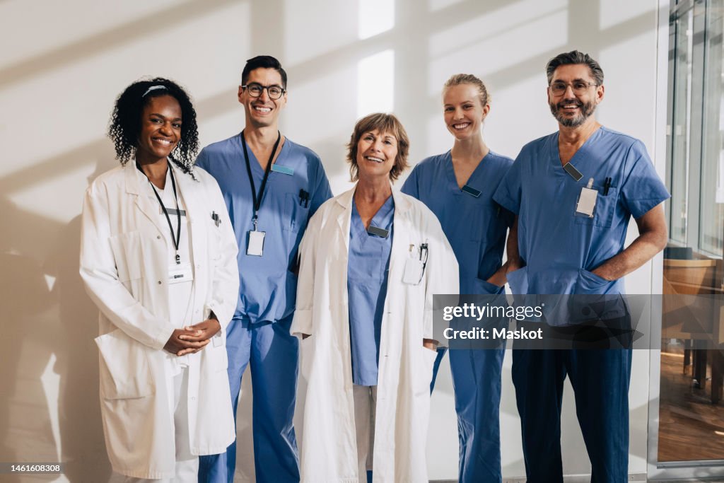 Sunlight falling on happy multiracial medical professionals standing in hospital