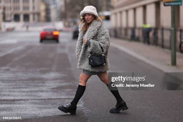 Sonia Lyson seen wearing Louis Vuitton black leather logo pattern bag, Prada black shiny leather loafer, Wolford black transparent socks, Edited grey...