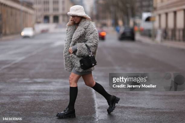 Sonia Lyson seen wearing Louis Vuitton black leather logo pattern bag, Prada black shiny leather loafer, Wolford black transparent socks, Edited grey...