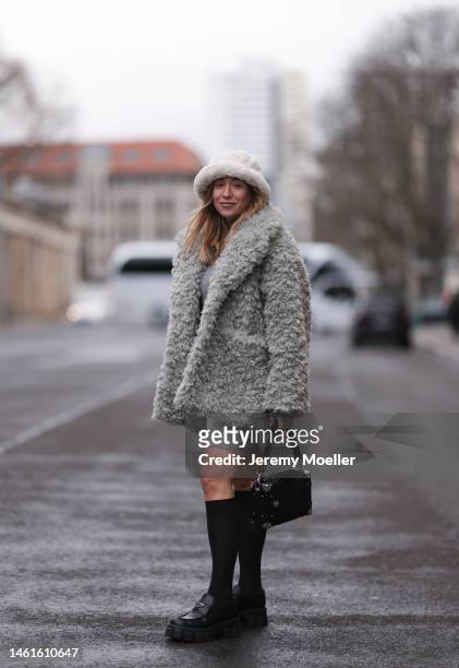 Sonia Lyson seen wearing Louis Vuitton black leather logo pattern bag, Prada black shiny leather loafer, Wolford black transparent socks, Edited grey...