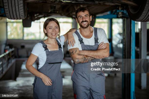 zwei zufriedene autoservice-mitarbeiter - motorfahrzeug stock-fotos und bilder