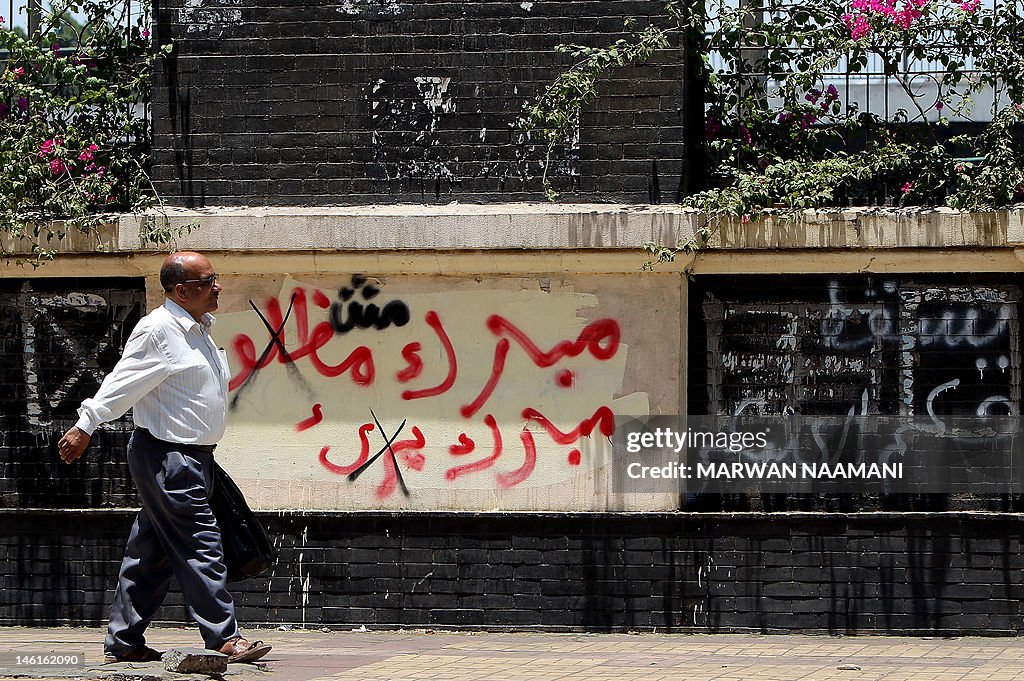 An Egyptian man walks past crossed out g