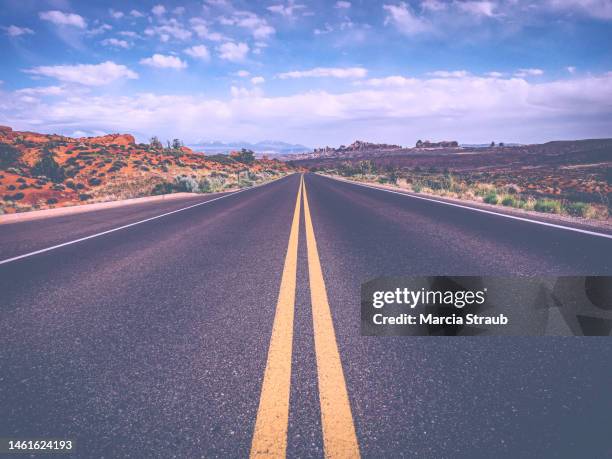 looking down the road in the desert - linea gialla foto e immagini stock