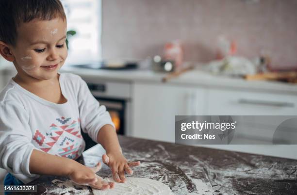 a boy is playing in the kitchen with flour - pie face stock pictures, royalty-free photos & images