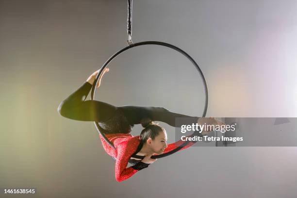 young acrobat performing on aerial hoop - contortionist stock pictures, royalty-free photos & images