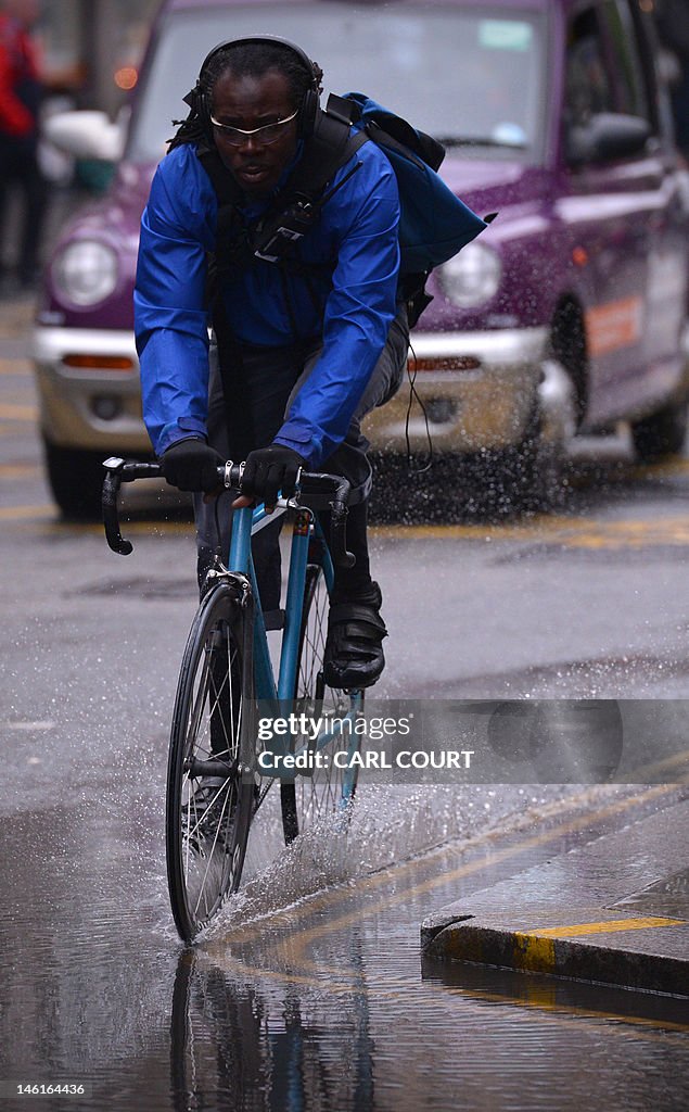 A cyclist rides through a puddle left by