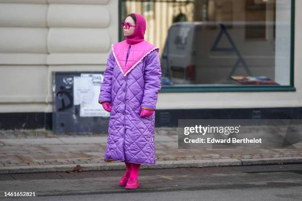 Guest wears neon pink sunglasses, a neon pink wool hoodie / balaclava, a purple quilted long puffer jacket with a large pink collar, pink quilted...