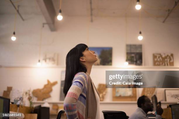 businesswoman looking up in office - asian ceiling stock-fotos und bilder