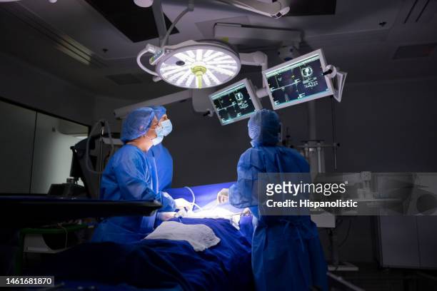 équipe de chirurgiens regardant une image dans le moniteur de la salle d’opération - surgery photos et images de collection